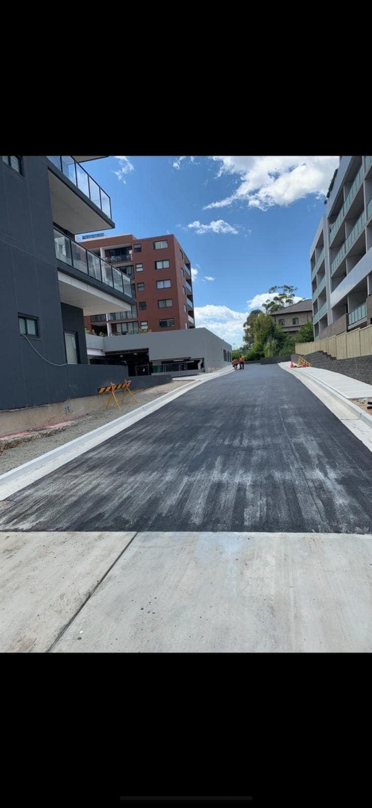 Asphalt access road between buildings
